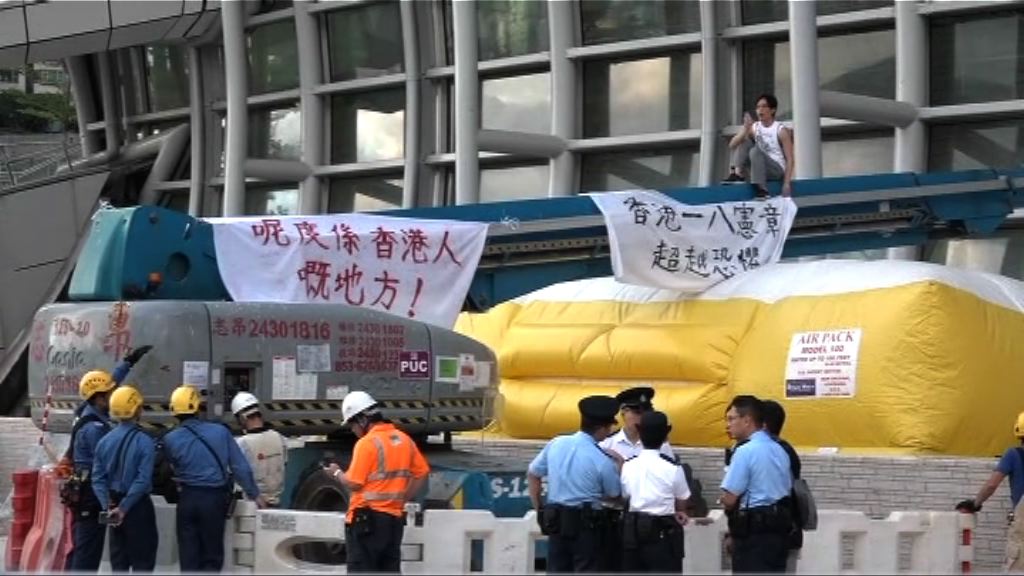 一名男子到高鐵西九龍站外懸掛橫額