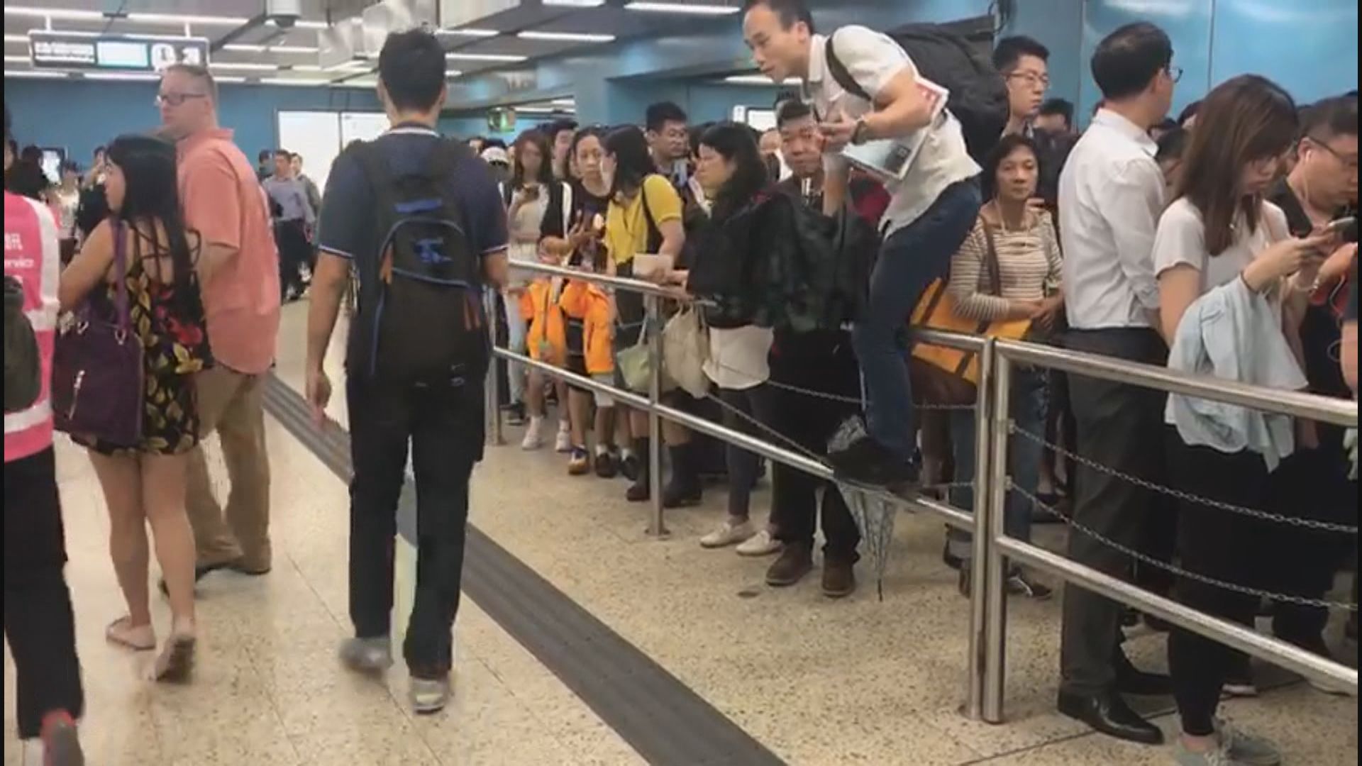 港鐵站內有市民不耐煩爬過欄杆中途離開