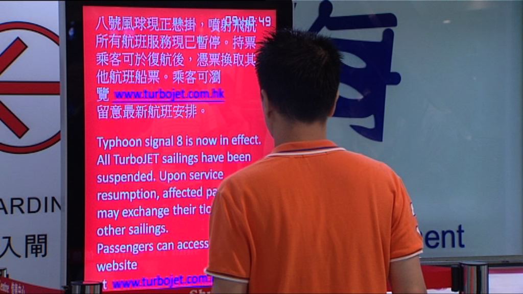 八號信號下有旅客在港澳碼頭等候客輪復航